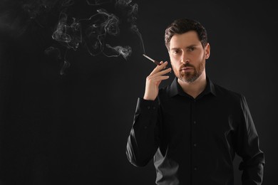 Photo of Man using cigarette holder for smoking on black background, space for text
