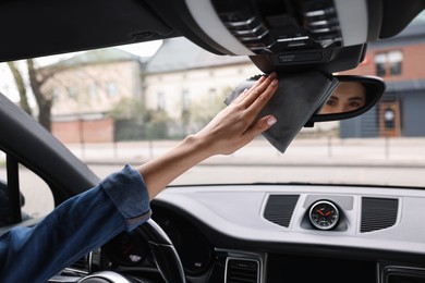 Woman wiping her modern car with rag, closeup