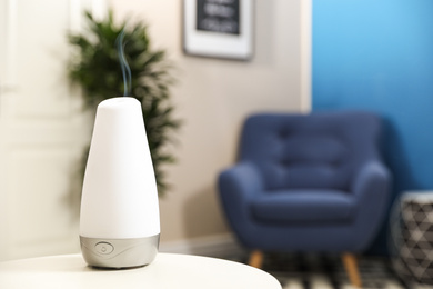 Aroma oil diffuser on white table at home, space for text. Air freshener