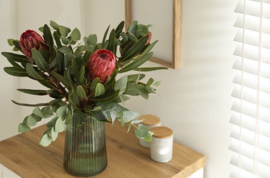 Vase with beautiful Protea flowers on table indoors