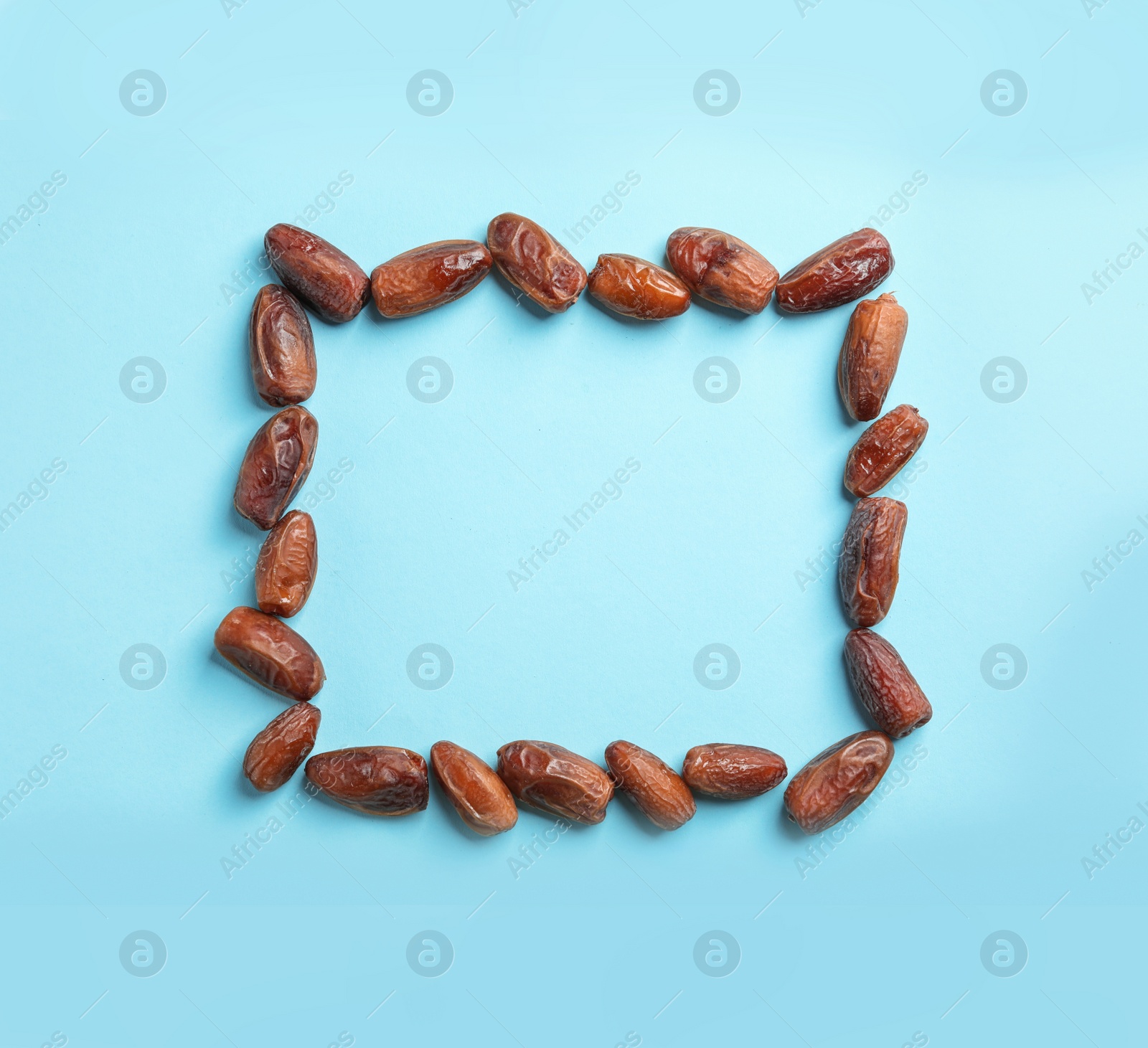 Photo of Frame made of sweet dried date fruits on color background, top view with space for text