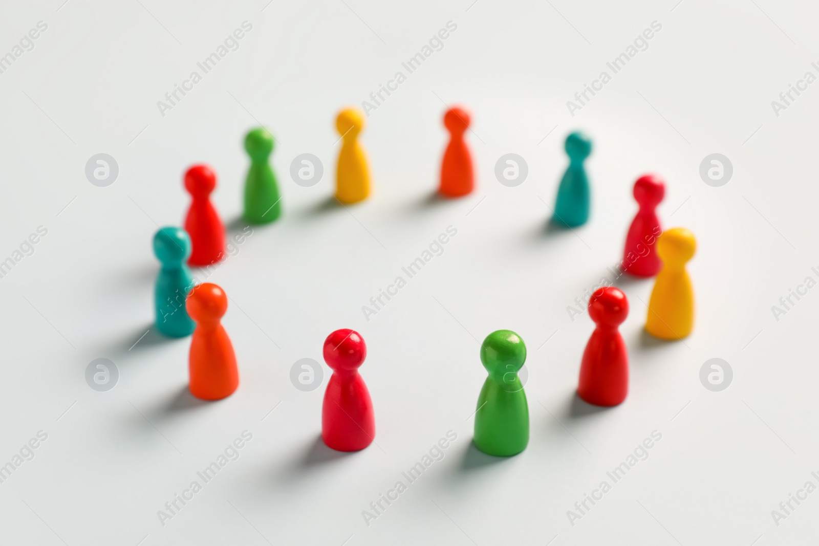 Photo of Colorful pawns on white background. Social inclusion concept