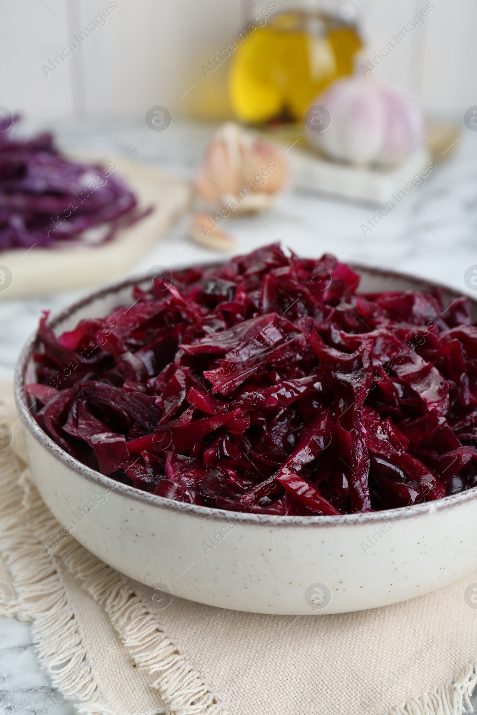 Photo of Tasty red cabbage sauerkraut on white marble table, closeup