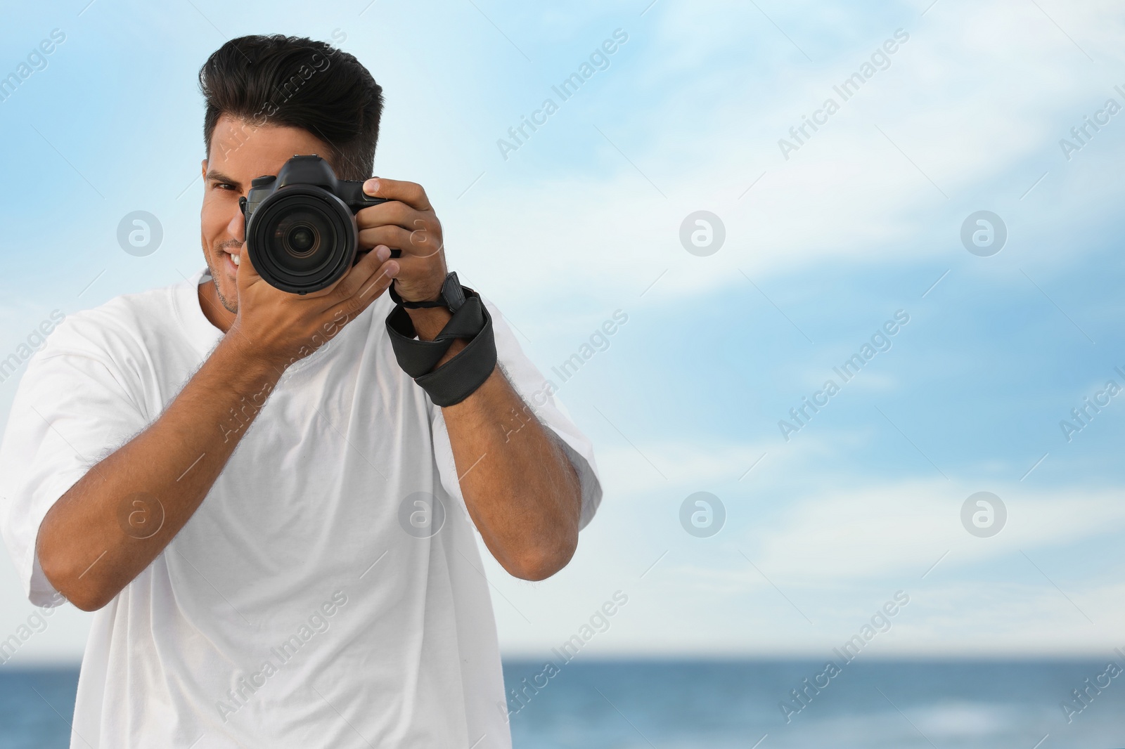 Photo of Photographer taking picture with professional camera near sea