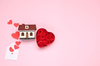 Photo of Long-distance relationship concept. House model, rose flowers and paper hearts flying out of envelope, flat lay with space for text