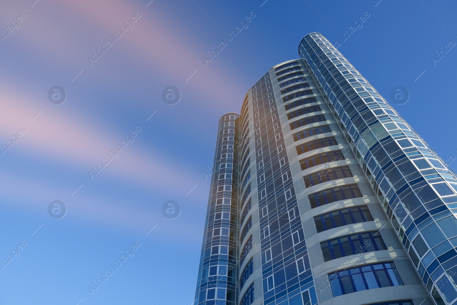 Photo of Beautiful skyscraper against blue sky on sunny day, low angle view