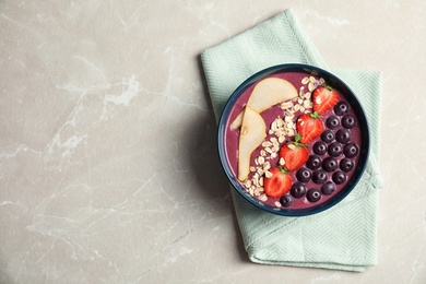 Photo of Flat lay composition with bowl of tasty acai smoothie on gray table