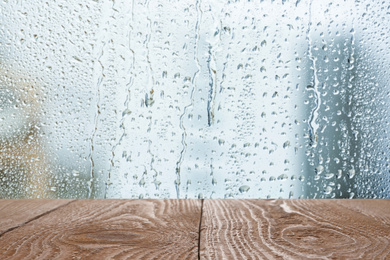 Image of Wooden table near window on rainy day