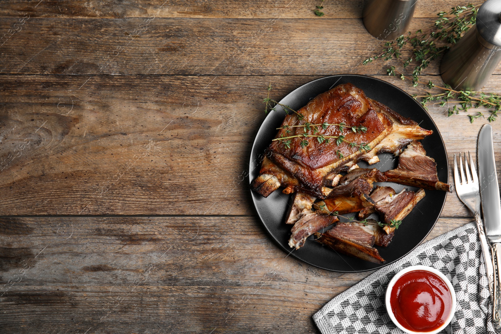 Photo of Delicious roasted ribs served on wooden table, flat lay. Space for text