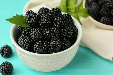 Bowl of fresh ripe blackberries on turquoise wooden table, closeup