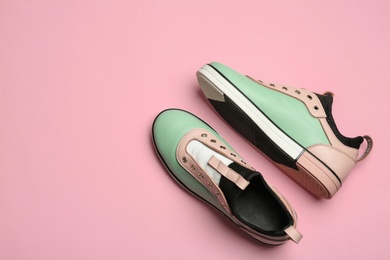 Flat lay composition of stylish shoes on color background, space for text