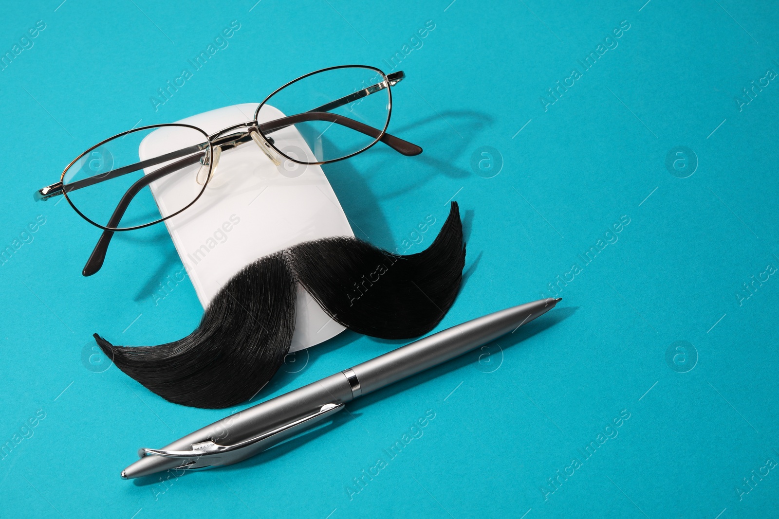 Photo of Composition with artificial moustache and glasses on light blue background, space for text