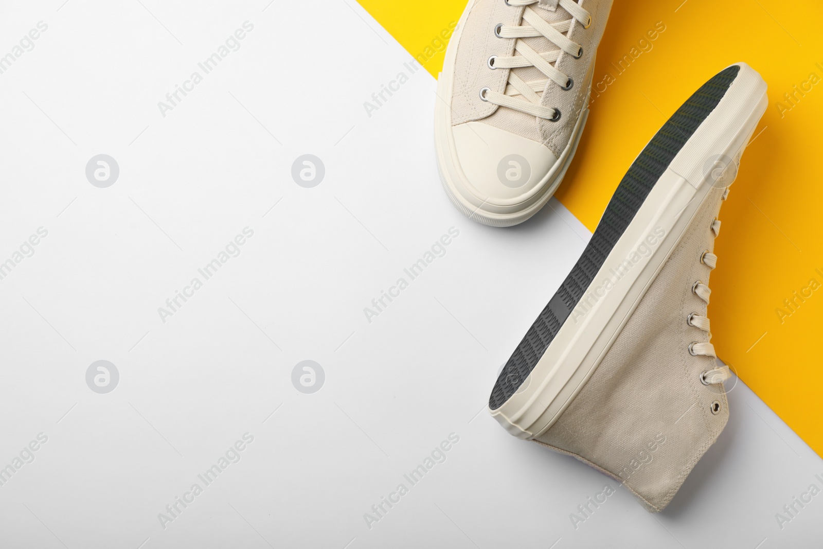 Photo of Pair of stylish sneakers on color background, top view