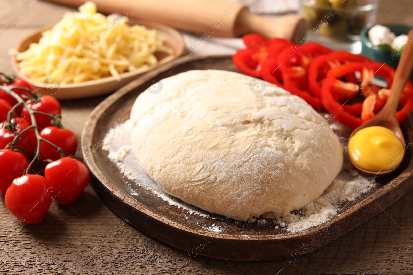 Photo of Pizza dough and products on wooden table, closeup