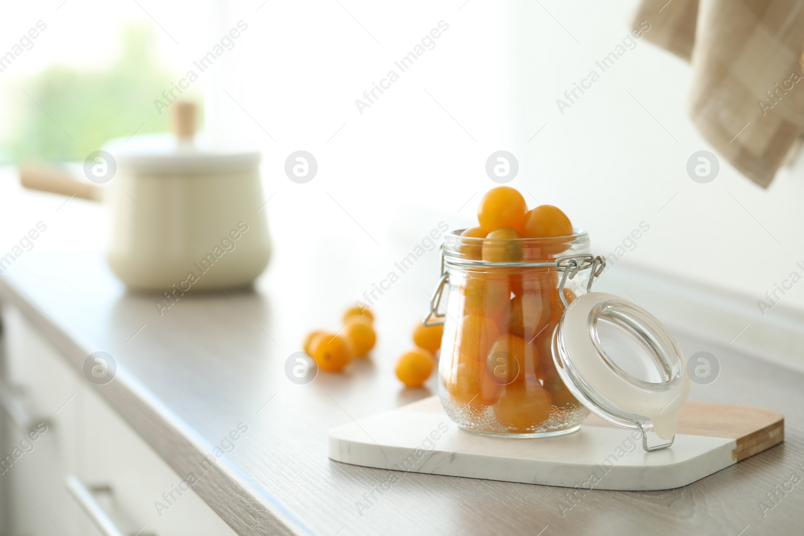 Photo of Pickling jar with fresh tomatoes on counter in kitchen. Space for text