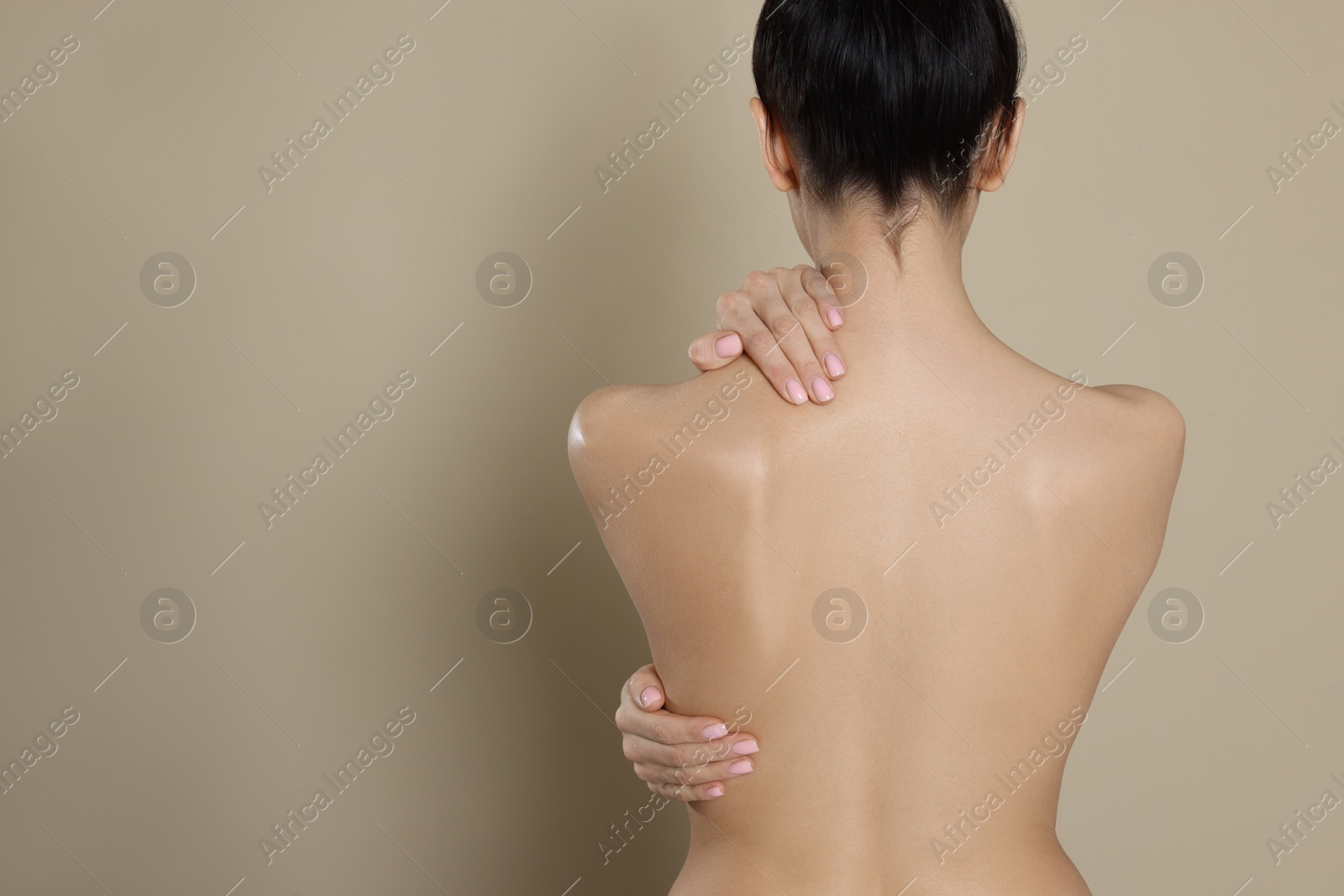 Photo of Back view of woman with perfect smooth skin on beige background, space for text