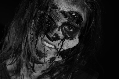 Photo of Scary zombie on dark background, black and white effect. Halloween monster