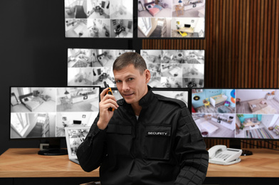 Photo of Security guard with portable transmitter at workplace in office