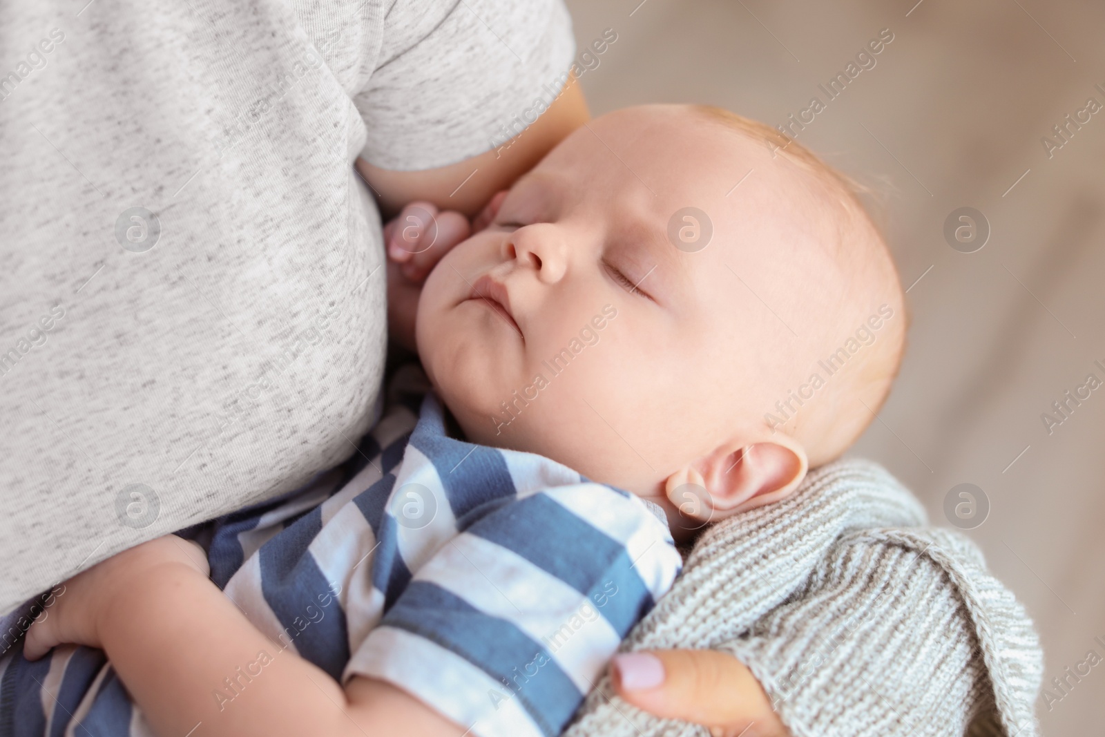 Photo of Mother with her sleeping baby at home, closeup view