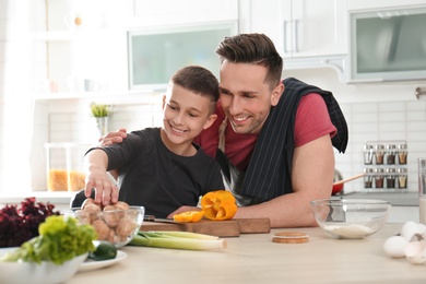 Dad and son cooking together in kitchen