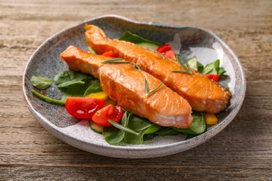 Photo of Healthy meal. Tasty grilled salmon with vegetables and spinach on wooden table