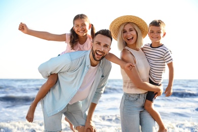 Photo of Happy family on beach near sea. Summer vacation