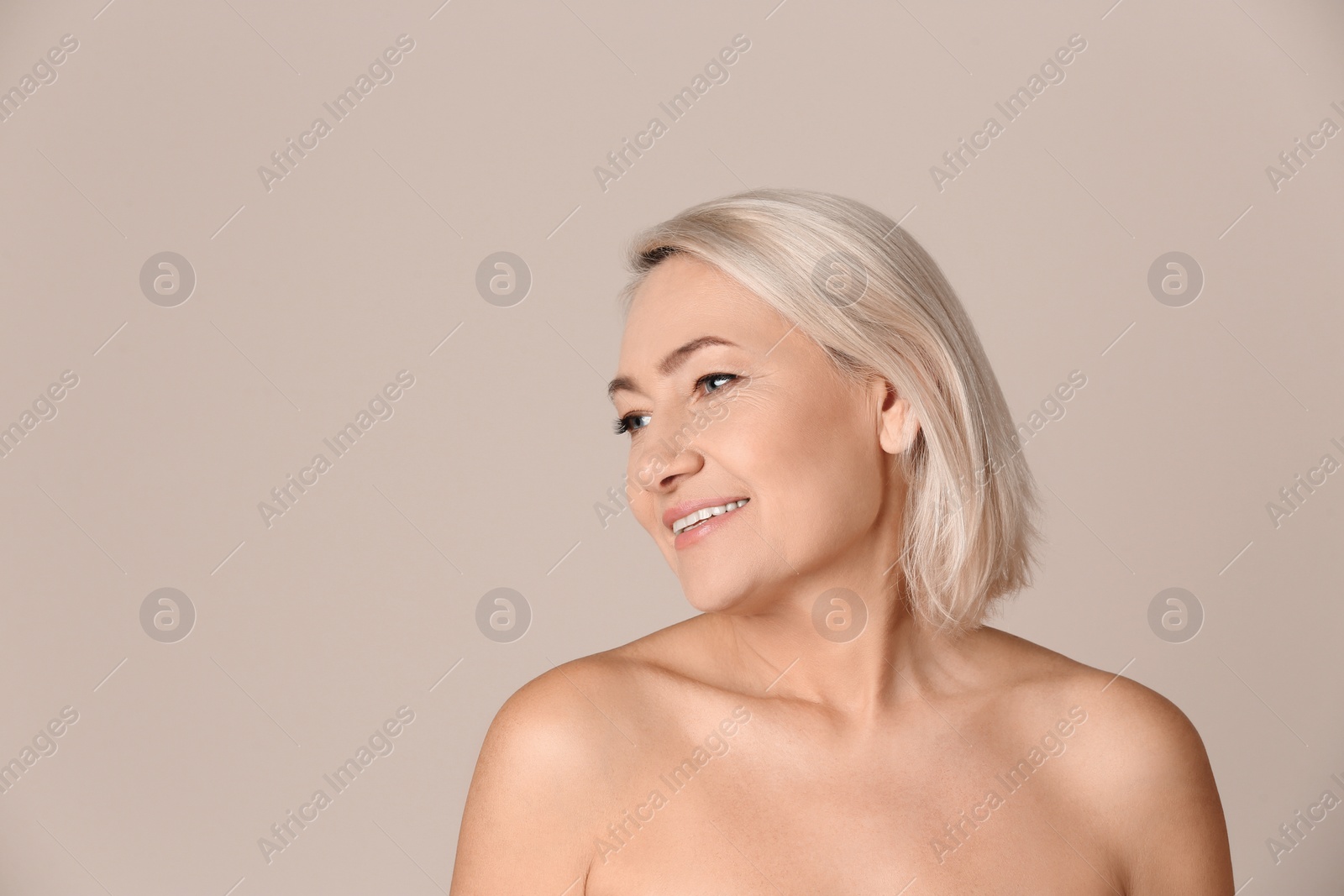 Photo of Portrait of beautiful mature woman on beige background. Space for text