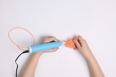 Boy drawing with stylish 3D pen on white background, top view