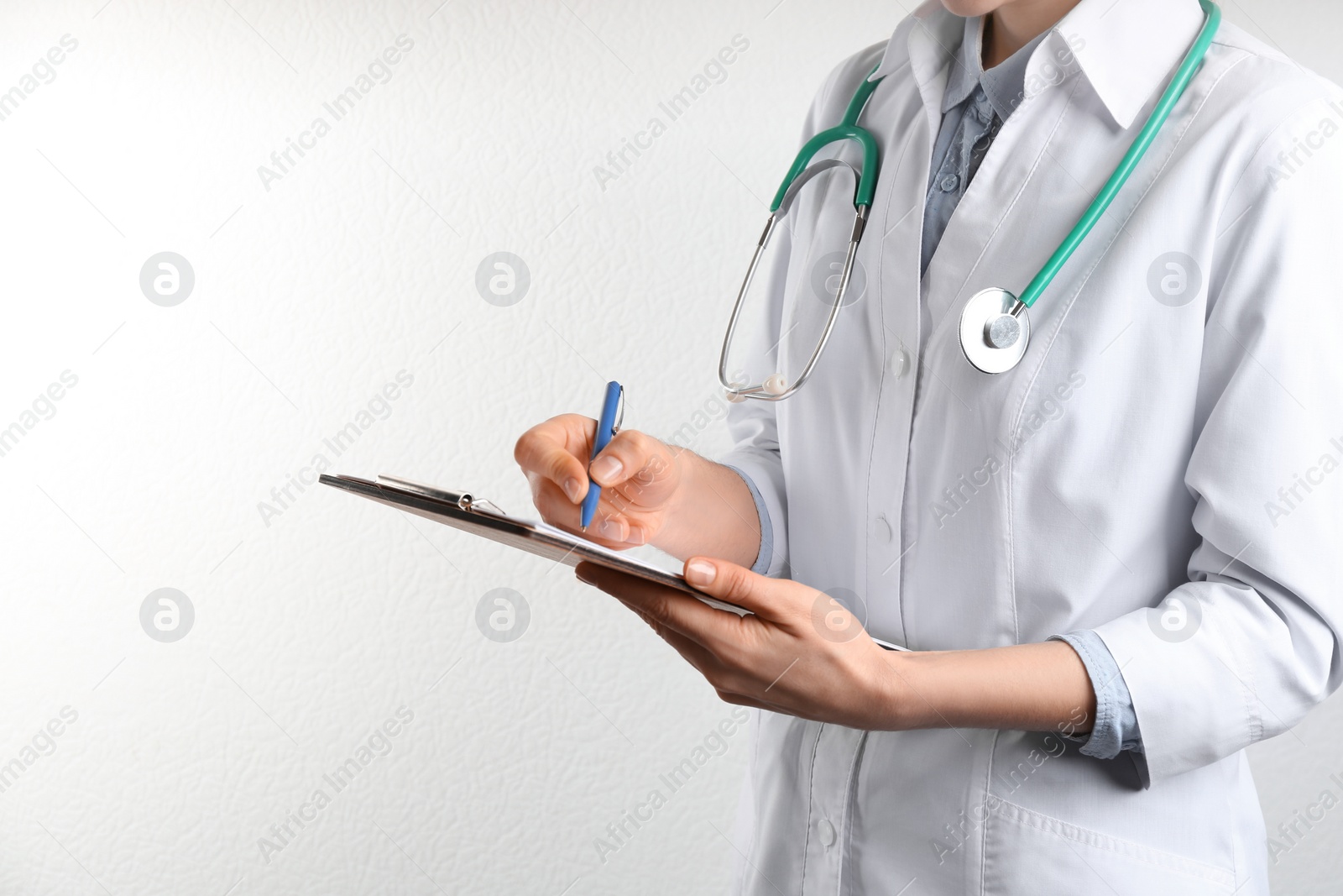 Photo of Doctor with stethoscope and clipboard on white background, closeup. Medical service