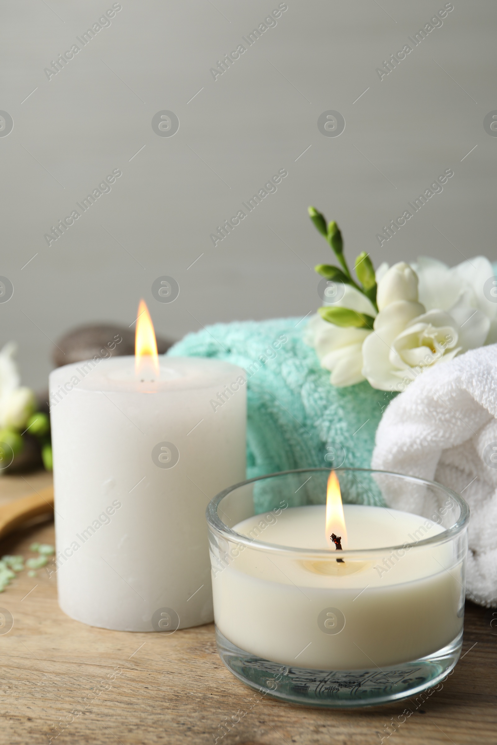 Photo of Beautiful composition with burning candles and different spa products on wooden table