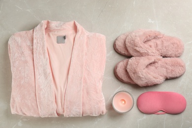 Photo of Flat lay composition with house slippers, sleeping mask and robe on light background