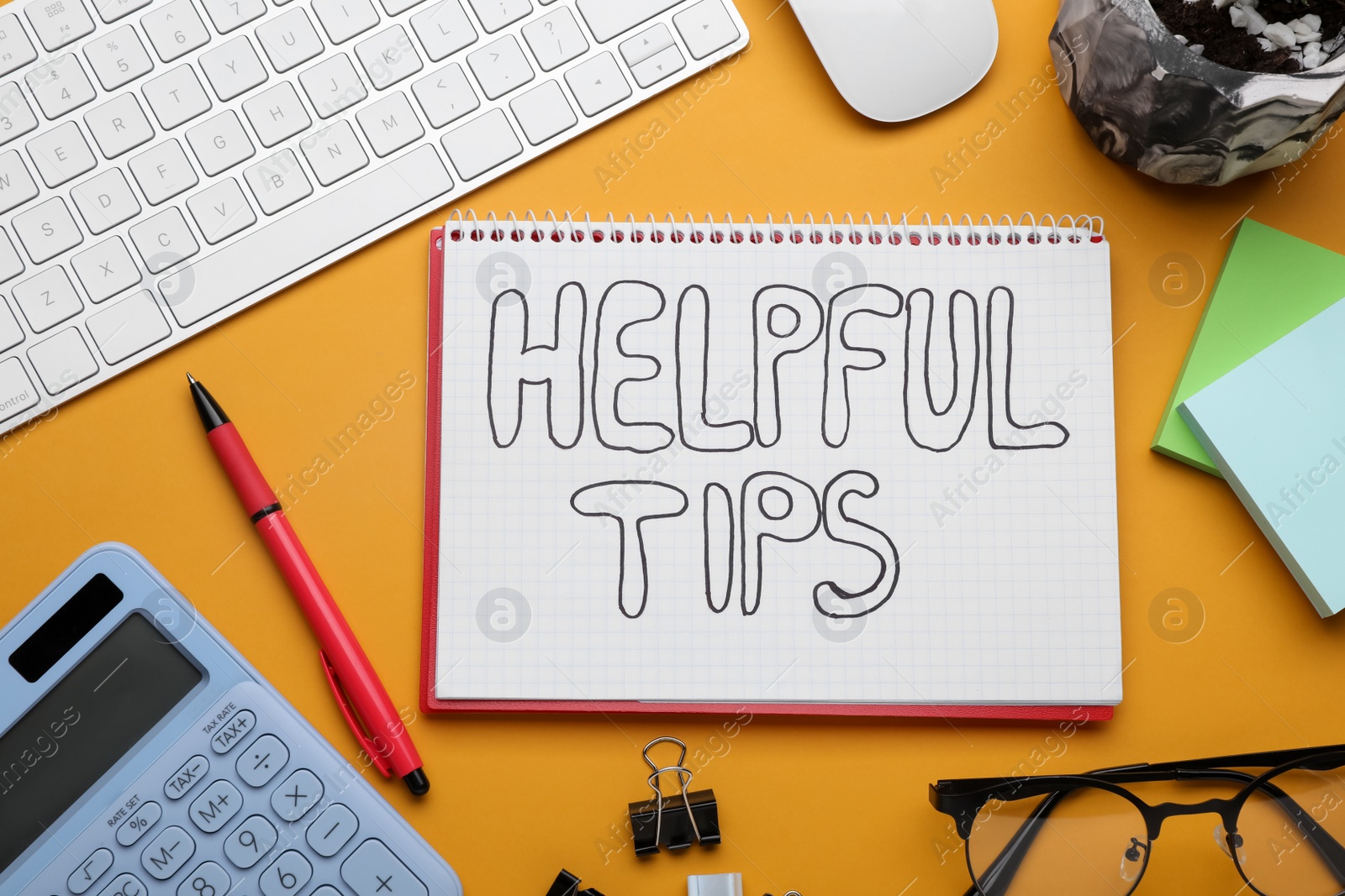 Photo of Helpful Tips. Flat lay composition with notebook, calculator and computer keyboard on orange background