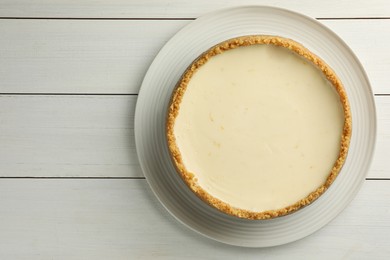 Photo of Tasty vegan tofu cheesecake on white wooden table, top view. Space for text