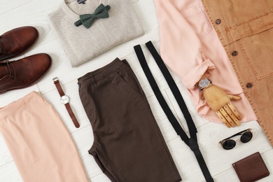 Photo of Flat lay set of stylish clothes and accessories on wooden floor