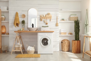 Stylish bathroom interior with modern washing machine