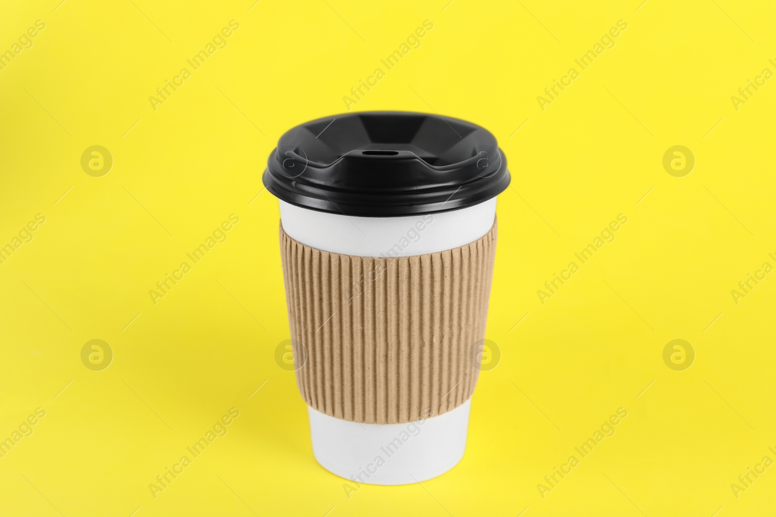 Photo of Paper cup with plastic lid on yellow background. Coffee to go