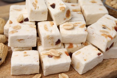 Pieces of delicious nutty nougat on table, closeup