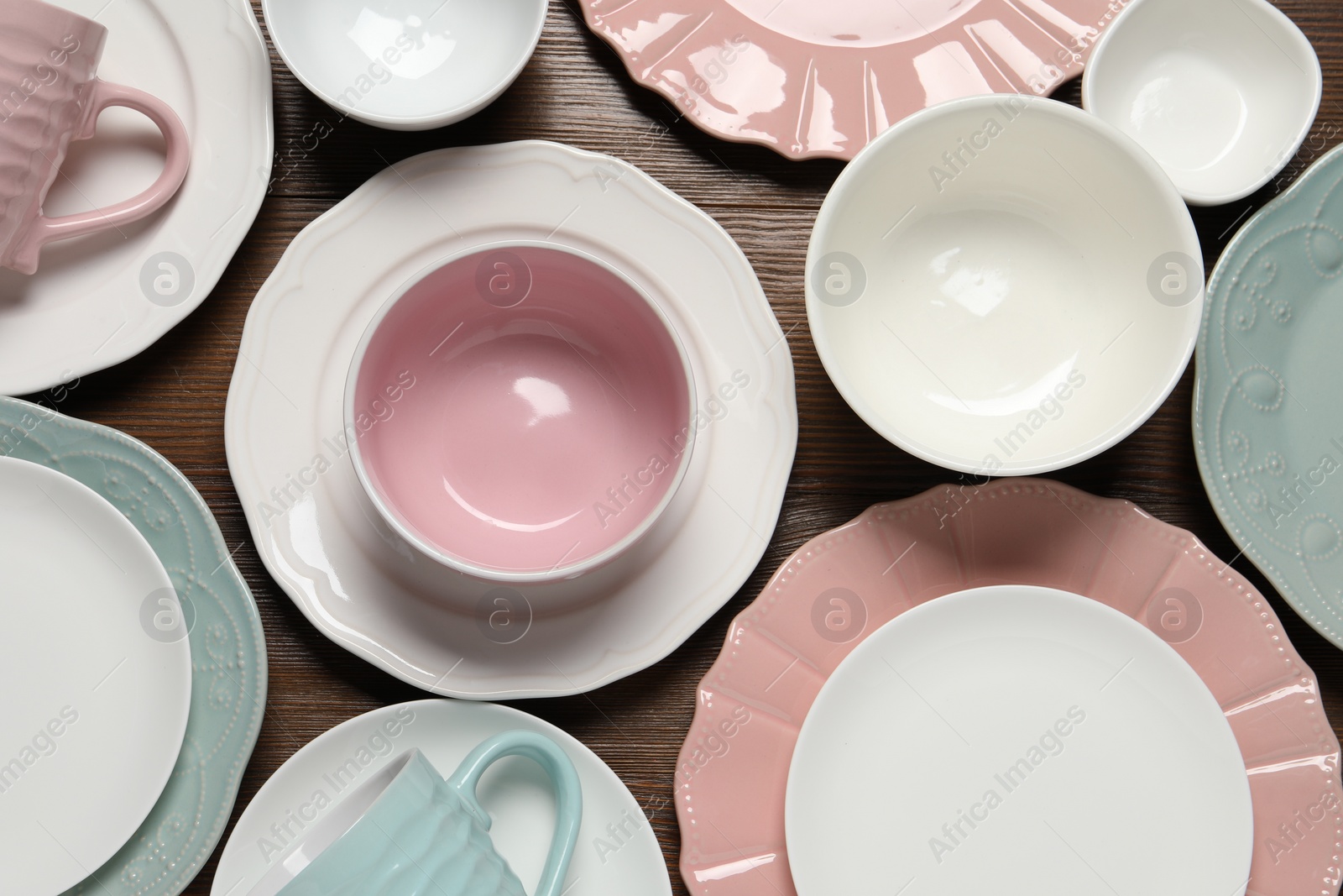 Photo of Beautiful ceramic dishware and cups on wooden table, flat lay