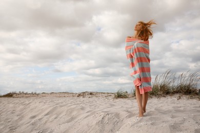 Beautiful woman with beach towel on sand