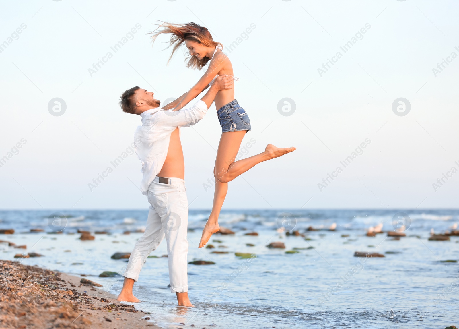 Photo of Young couple spending time together on beach