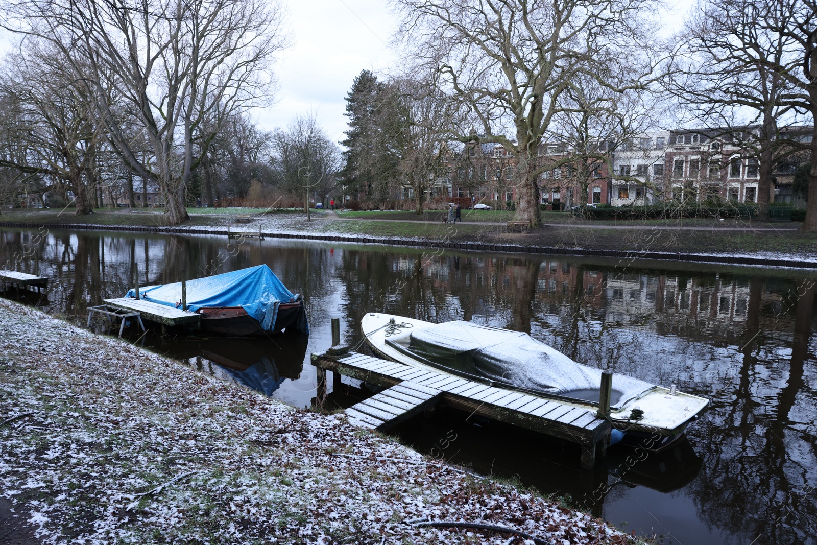 Photo of Picturesque view of water canal with moored boats on winter day