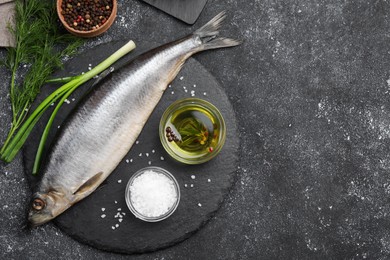 Photo of Delicious salted herring and ingredients on dark grey table, flat lay. Space for text