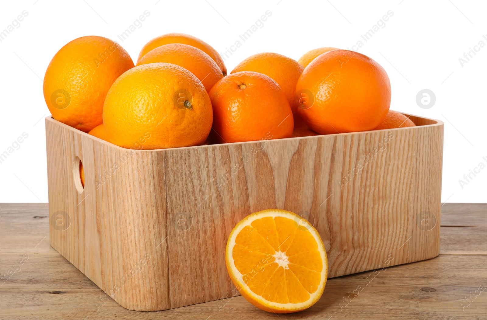 Photo of Fresh oranges in crate on wooden table against white background