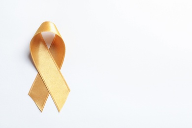 Photo of Gold ribbon on white background, top view. Cancer awareness