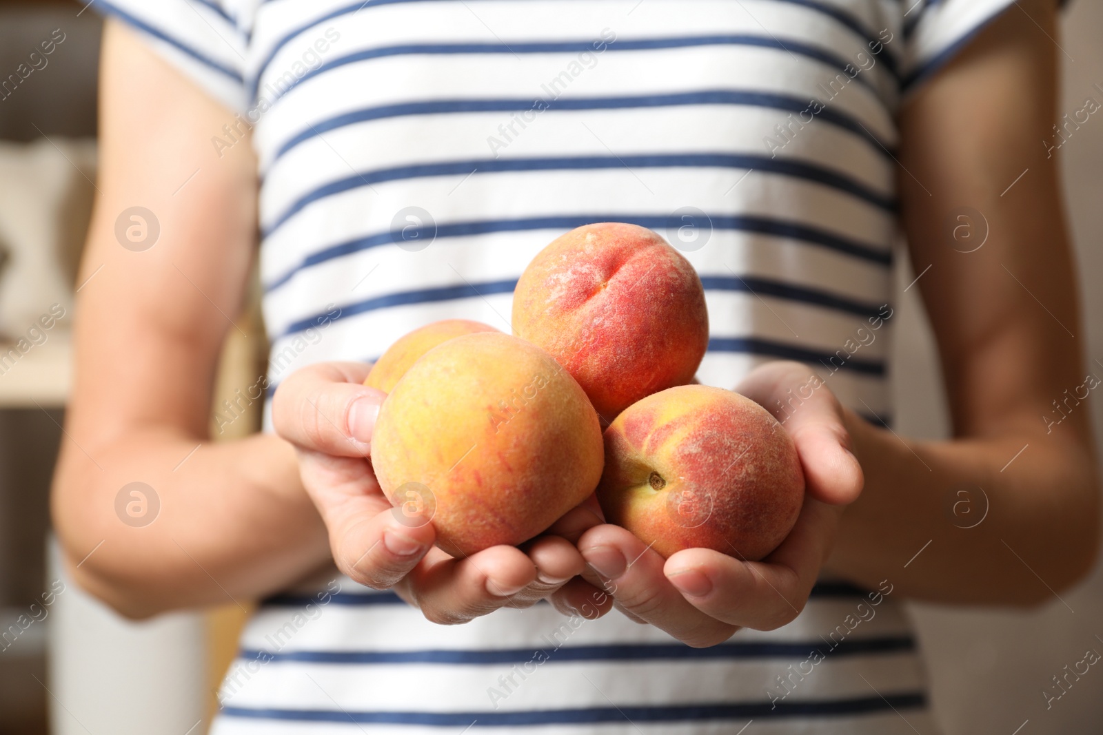 Photo of Woman holding delicious juicy ripe peaches, closeup