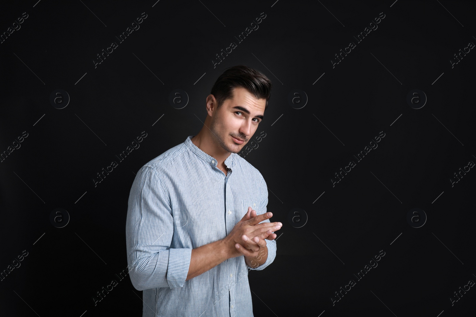 Photo of Portrait of handsome young man on black background