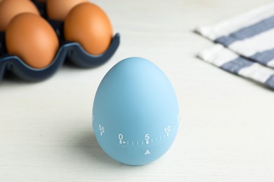 Kitchen timer and eggs on white table