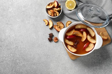 Delicious compote with dried apple slices and anise in pot on grey table, flat lay. Space for text