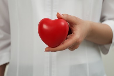 Photo of Doctor holding red heart, closeup. Cardiology concept