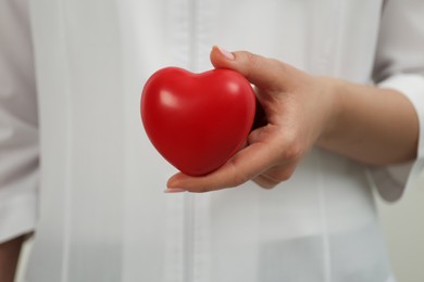 Doctor holding red heart, closeup. Cardiology concept